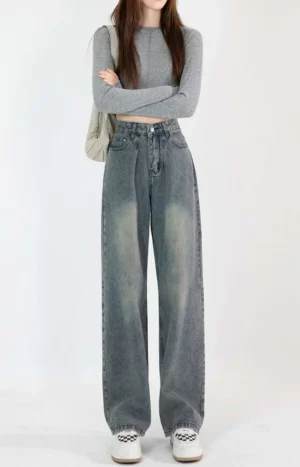 Front view of vintage blue high-waisted wide-leg jeans showing the waist pleats, classic pockets, and worn faded denim wash