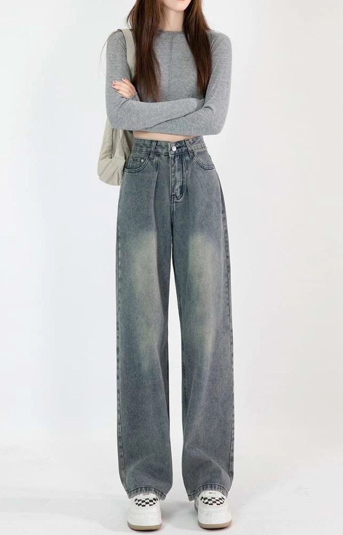 Front view of vintage blue high-waisted wide-leg jeans showing the waist pleats, classic pockets, and worn faded denim wash