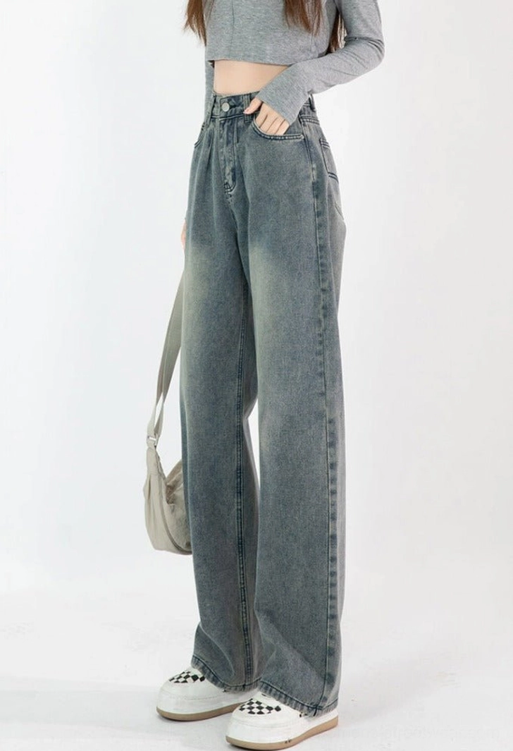 Left three-quarter view of high-waisted vintage blue wide-leg jeans with clean topstitching, front pocket, and loose full-length leg