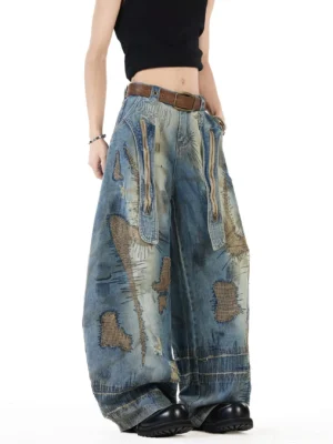 Front three quarter view of vintage blue patchwork balloon jeans with distressed embroidery, oversized utility pockets, ultra wide legs, faded denim wash, and frayed streetwear details