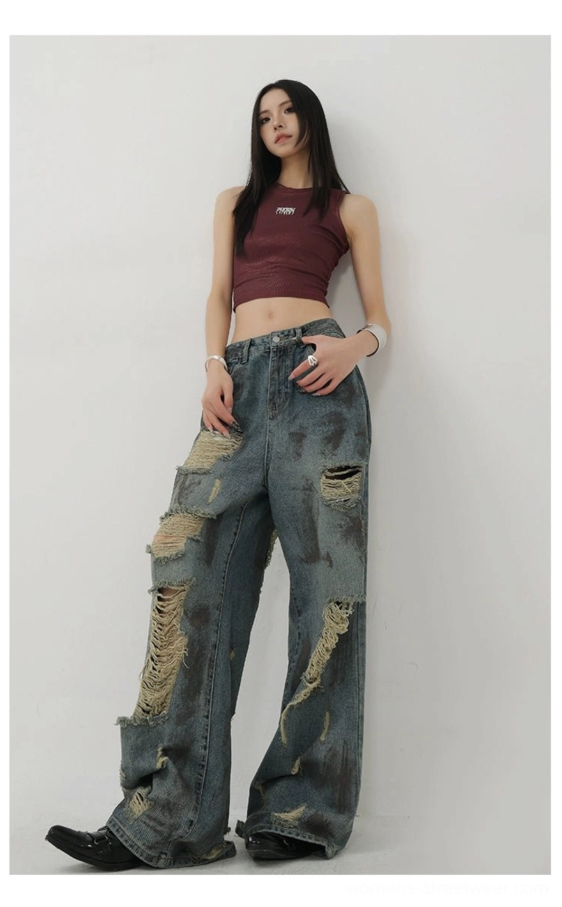 Vintage-inspired blue tie-dye wash jeans with dramatic frayed openings and contemporary streetwear proportions