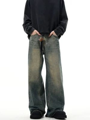 Full front view of vintage blue wide-leg jeans with distressed washed denim, leather toggle drawstring waist, loose streetwear silhouette, black washed sweatshirt, and platform loafers