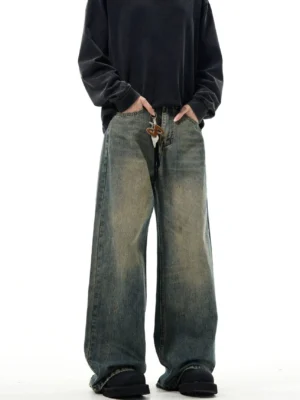 Close-up front view of vintage blue wide-leg jeans showing classic denim waistband, faded color gradient, front pockets, and leather drawstring detail