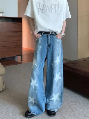 Vintage blue wide-leg denim jeans with white star print shown from the front in a relaxed streetwear outfit