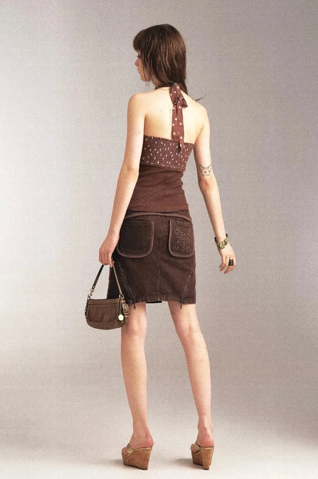 Back view of vintage brown denim pencil skirt showing rear patch pockets and slim fitted shape