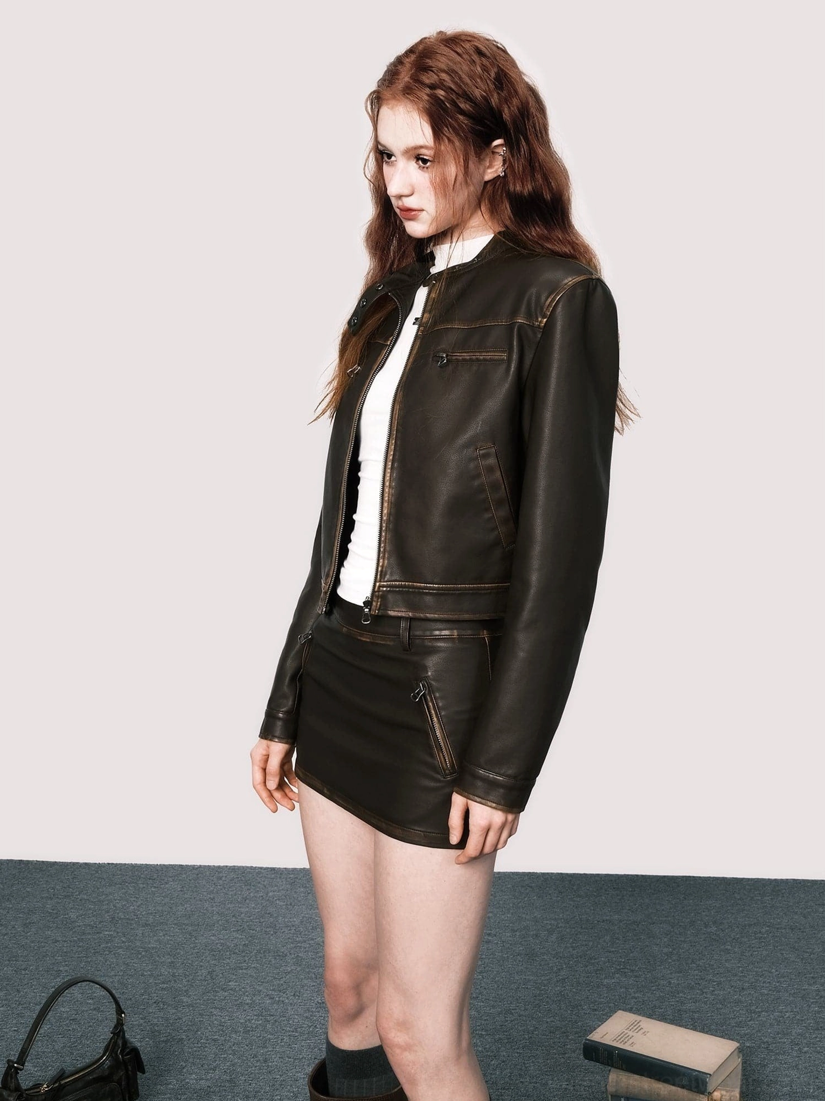 Side view of vintage brown faux leather cropped moto jacket and mini skirt Korean streetwear outfit