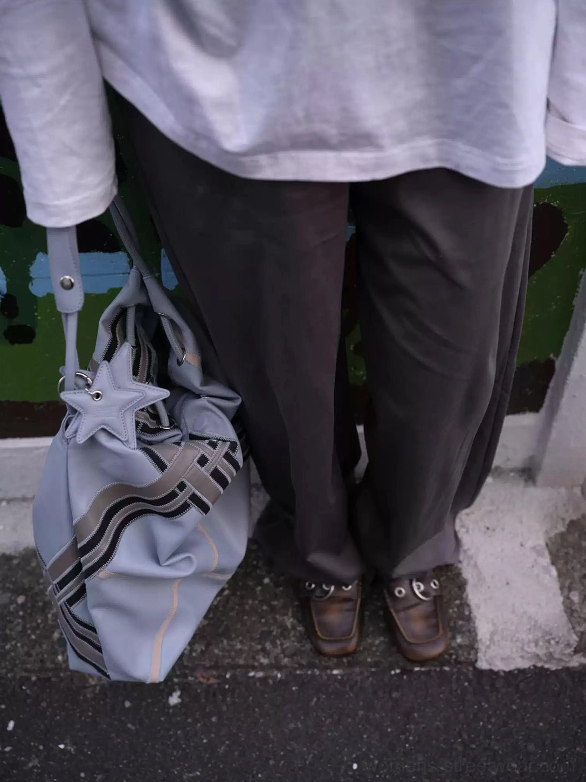 Vintage brown ruched buckle flats styled with wide leg trousers and gray star tote in a casual streetwear outfit