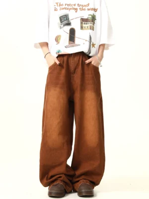Vintage brown wide leg denim jeans shown from the front with a relaxed fit, faded wash, and graphic white T-shirt