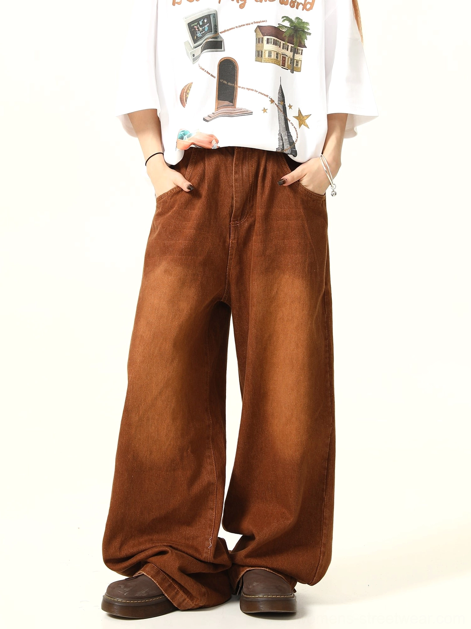Three-quarter front view of relaxed vintage brown wide leg jeans styled with a printed white tee and brown shoes