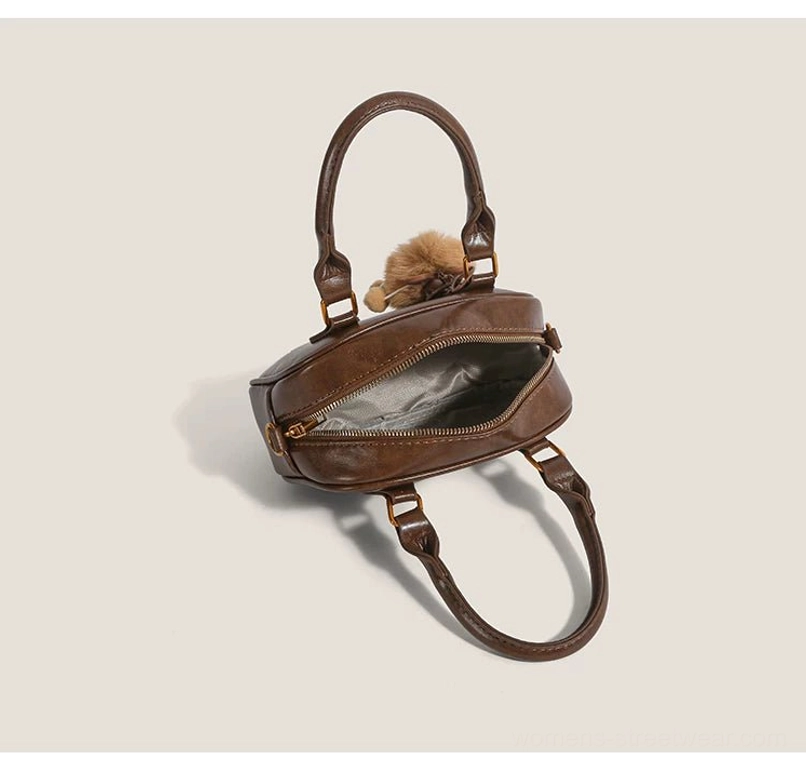 Open interior of vintage brown cub charm mini satchel crossbody bag with polyester lining and zippered top