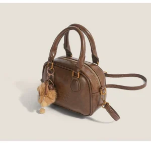 Vintage brown mini satchel crossbody streetwear bag showing zip top closure, detachable strap and plush cub charm