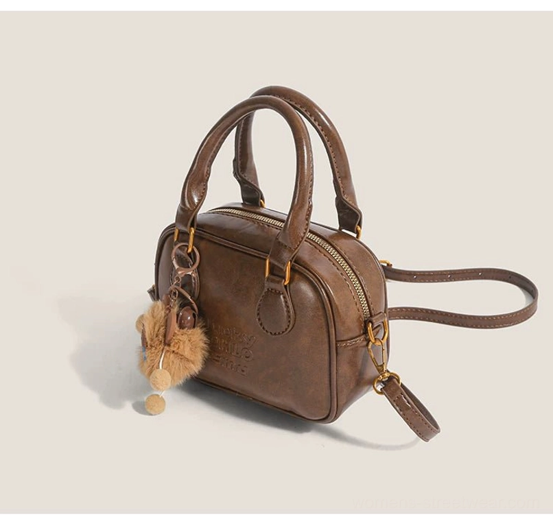Vintage brown mini satchel crossbody streetwear bag showing zip top closure, detachable strap and plush cub charm