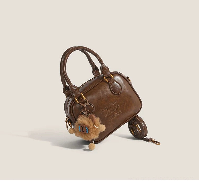 Brown vintage style PU mini satchel with embossed front detail, plush cub bag charm and detachable shoulder strap