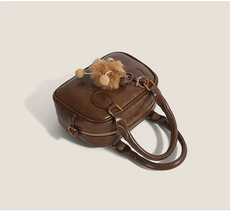 Top view of vintage brown cub charm mini satchel handbag with dual handles, top zipper and embossed PU texture