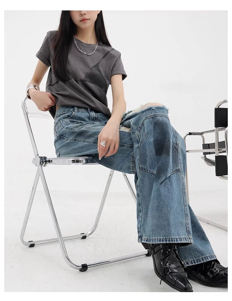 Vintage distressed wide-leg jeans hem and cuff detail displaying wide leg silhouette stacking effect on footwear and faded denim finish with natural wear appearance