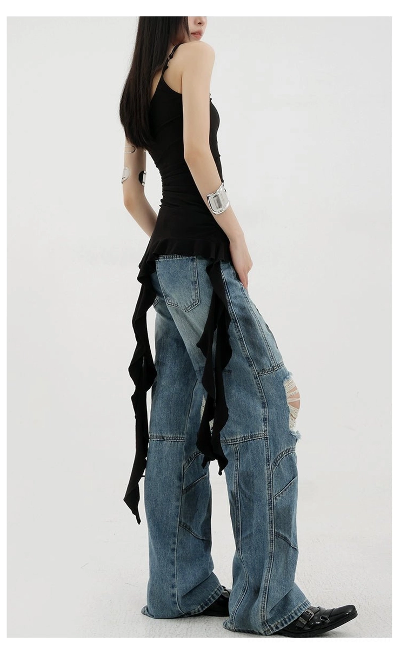 Vintage distressed wide-leg jeans detailed view of knee rip destruction points showcasing expert garment deconstruction technique and reinforced stitching on distressed areas