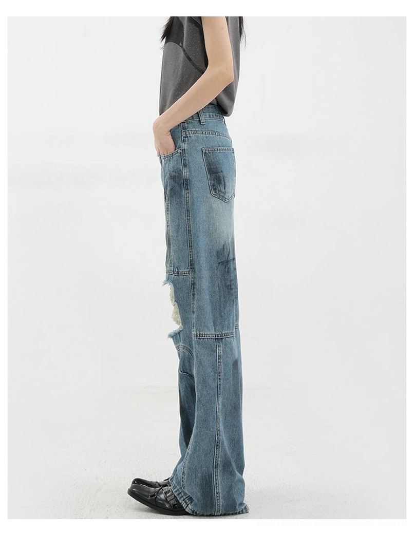 Vintage distressed wide-leg jeans worn with minimal white tee highlighting architectural seaming and distressed details as focal point of understated grunge outfit
