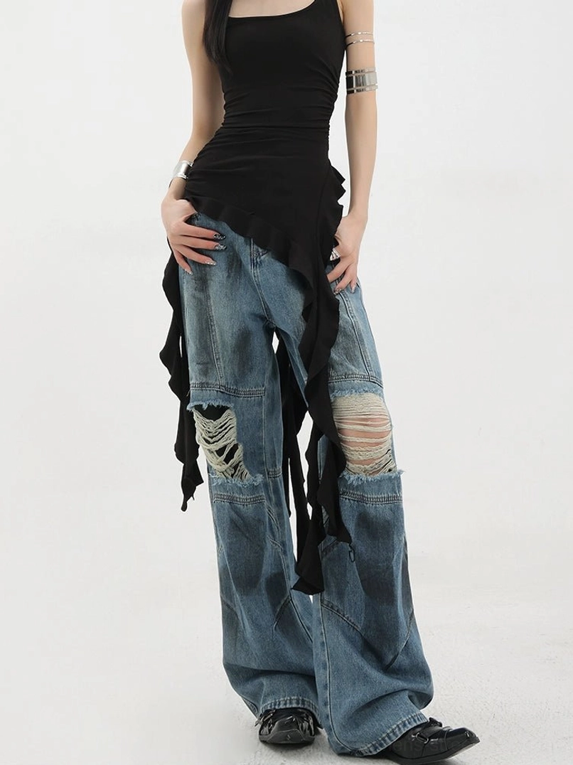 Vintage distressed wide-leg jeans right three-quarter side view on female model paired with black asymmetric camisole displaying worn denim finish ripped knee details wide leg silhouette side drapery