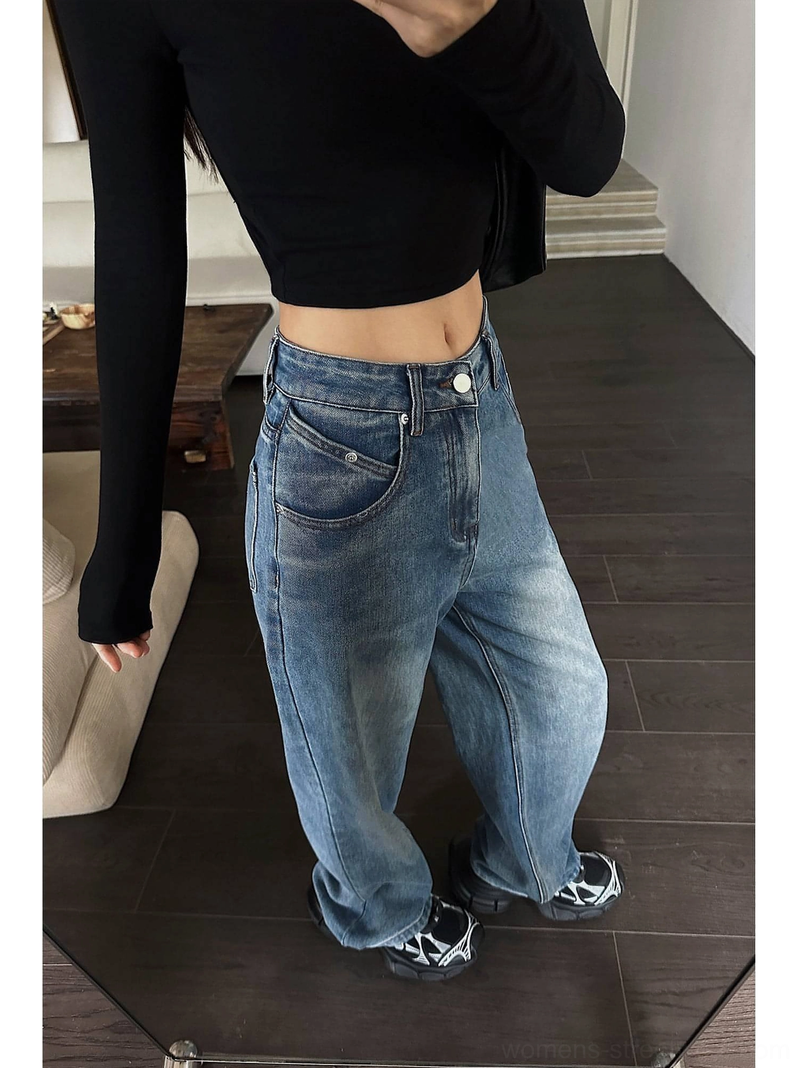 Close front-side view of vintage faded blue high-waist wide-leg jeans showing classic denim pockets and relaxed fit