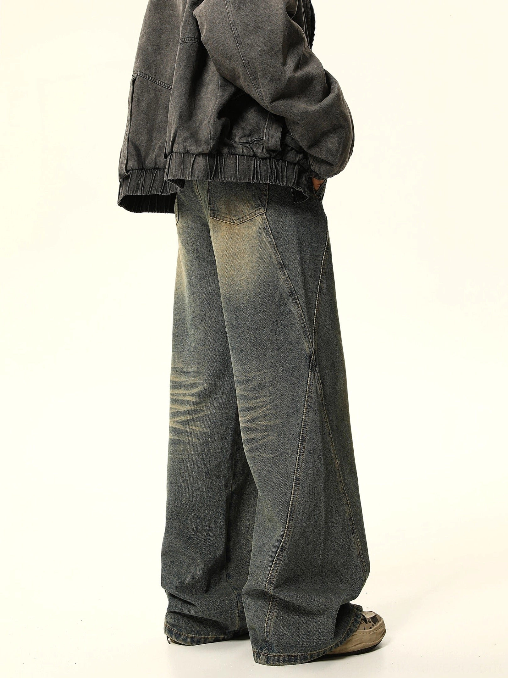 Rear full-body view of vintage faded blue wide-leg carpenter jeans styled with an oversized washed denim jacket