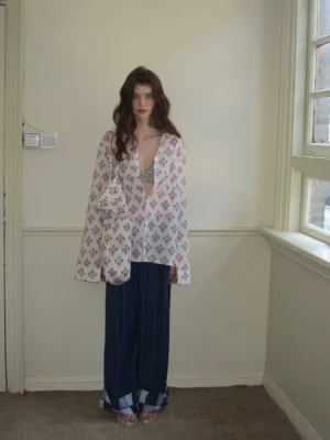 Full-body front view of a woman wearing a lightweight vintage floral print cotton kimono cardigan with wide-leg pants