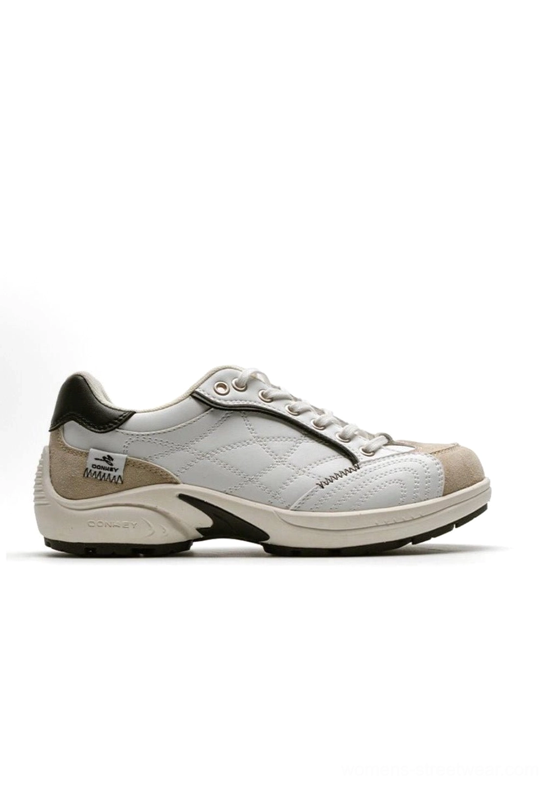 Angled perspective product photography of vintage German trainer sneaker highlighting curved colorblock overlays and architectural design elements