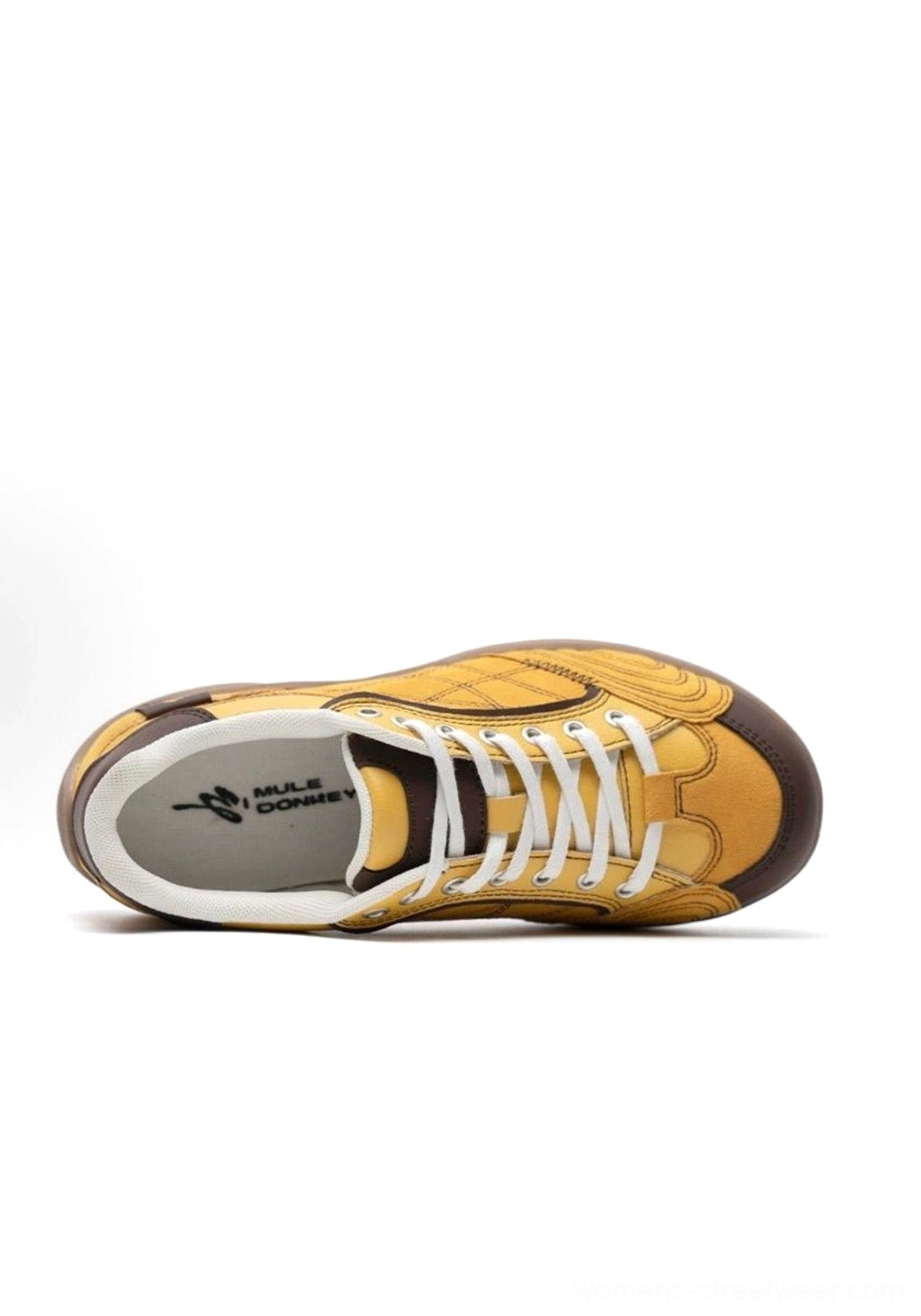 Interior flat lay shot of single left retro German trainer sneaker showing insole branding visible lace-up interior and yellow upper with brown rubber outsole