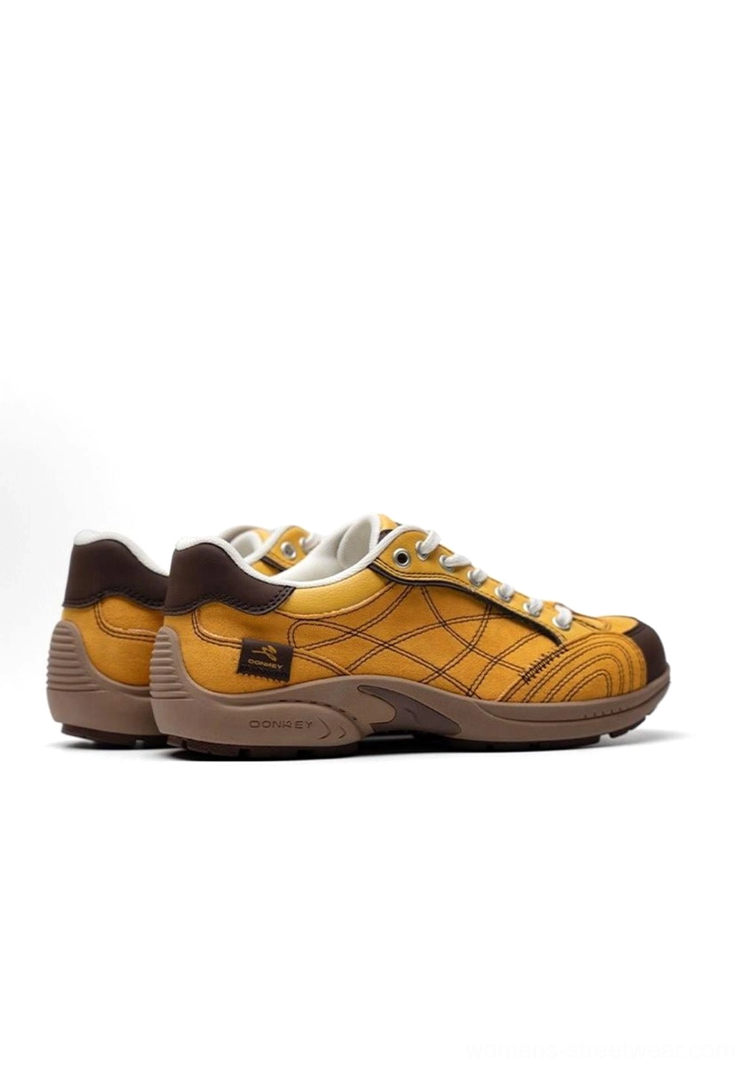 Rear view product shot of paired retro colorblock German trainer sneakers showing heel area with branded label unified yellow brown colorway