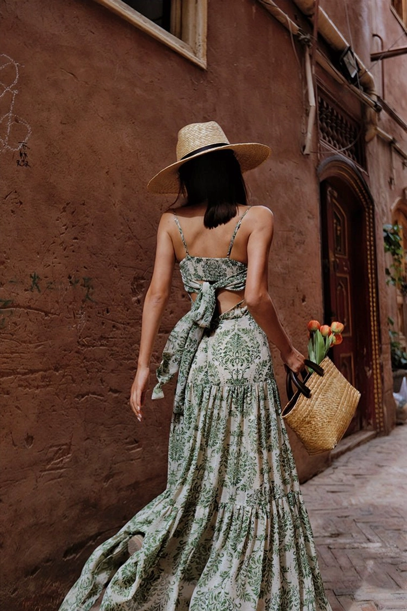 Vintage green floral spaghetti strap maxi dress back walking view with low back bow detail and tiered skirt