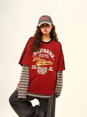 Burgundy vintage Los Angeles layered varsity streetwear tee with striped long sleeves worn with wide-leg pants