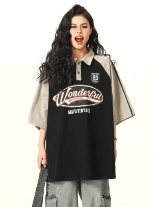 Black vintage oversized contrast raglan polo shirt with grey sleeves, retro graphic chest print, number 23 badge, and relaxed streetwear fit shown from the front