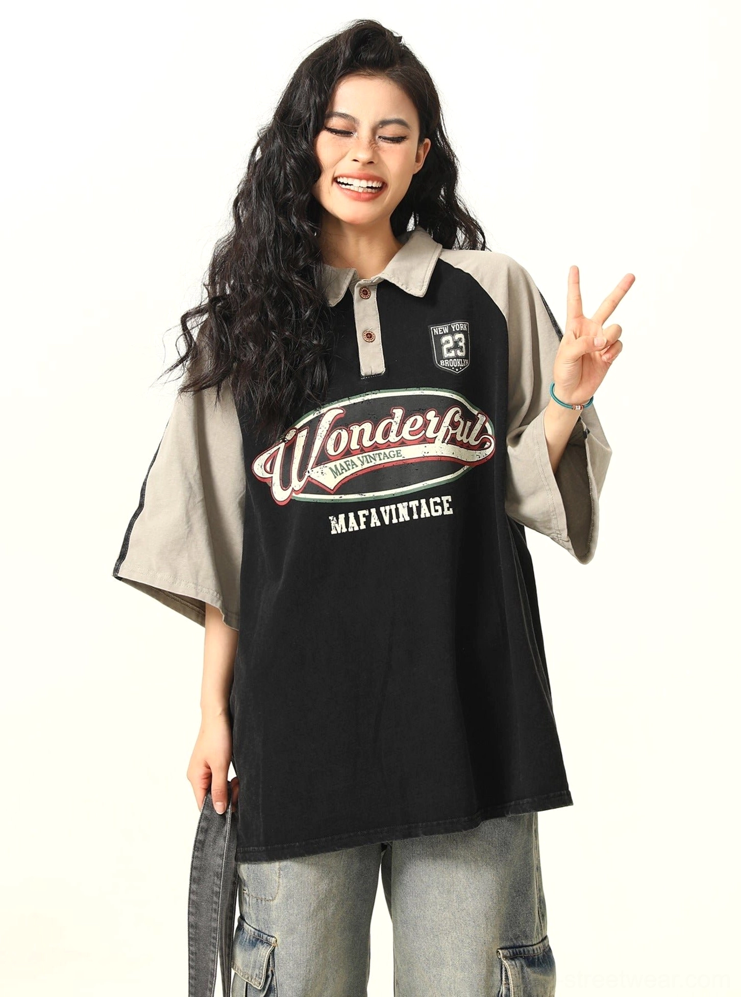 Vintage-style oversized polo T-shirt with relaxed loose fit, retro slogan graphic, and sporty contrast sleeves shown from the front