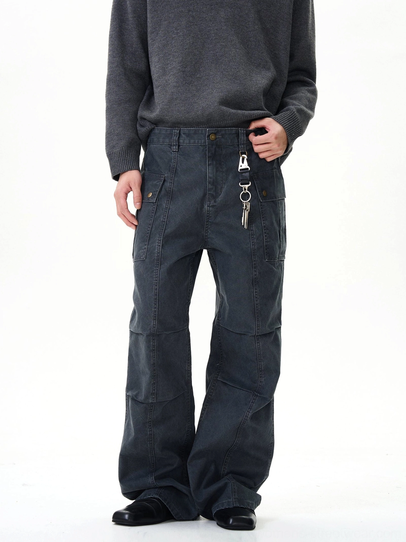 Dark grey vintage panel seam wide-leg cargo pants with flap pockets and metal hanging accessory styled with a grey knit sweater