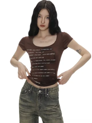 Close-up of coffee brown slim fit vintage text graphic baby tee with deep scoop neckline and cropped length