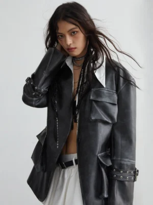 Woman wearing a vintage distressed PU leather utility jacket with 3D cargo pockets, buckle cuffs, and an oversized boxy streetwear fit