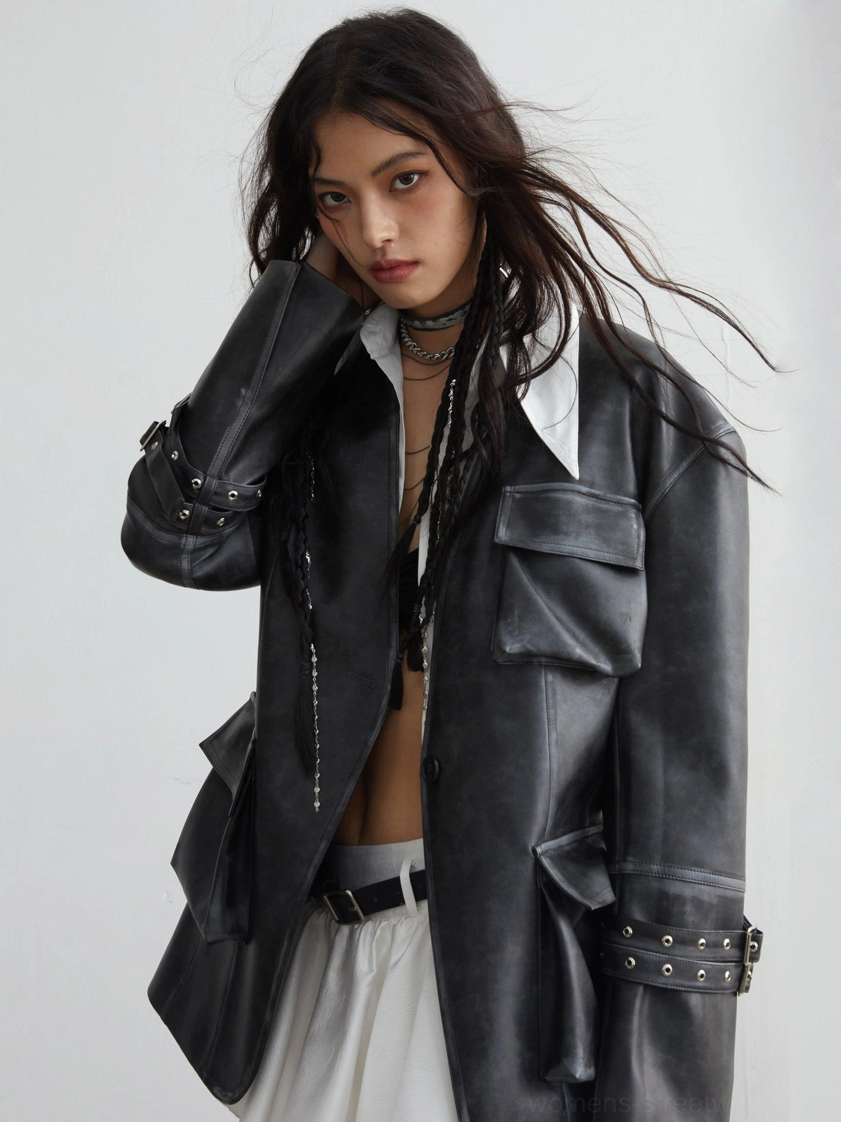 Woman wearing a vintage distressed PU leather utility jacket with 3D cargo pockets, buckle cuffs, and an oversized boxy streetwear fit
