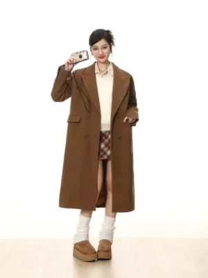 Full-body front view of a model wearing a vintage red and brown plaid high-waisted wool streetwear skirt with a brown wool coat and white top