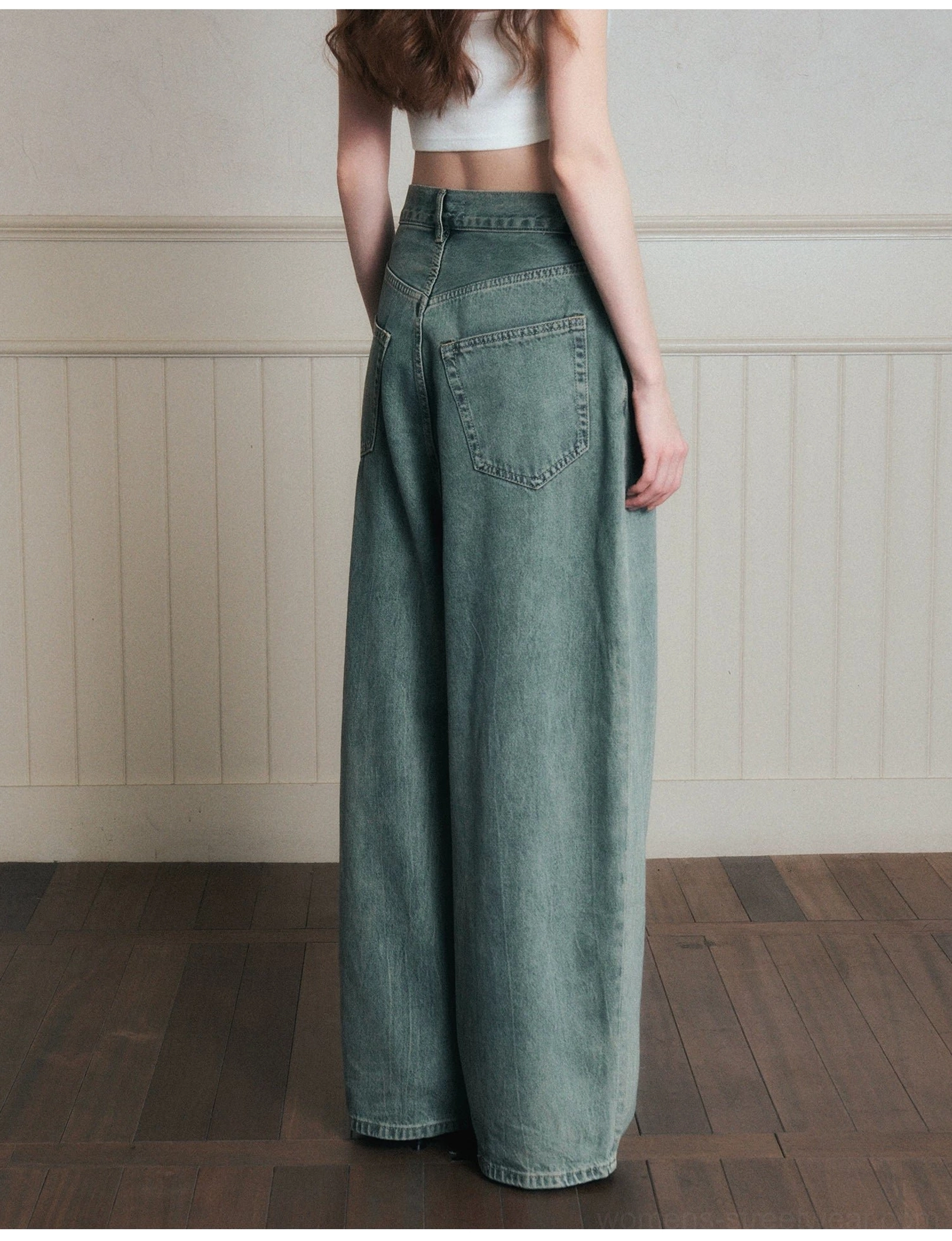 Back side view of vintage sage blue wide-leg jeans showing the relaxed waist, roomy leg cut, and authentic washed denim texture