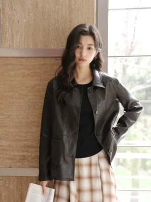 Women wearing a vintage short black leather jacket in a relaxed streetwear fit with a classic collar and plaid midi skirt