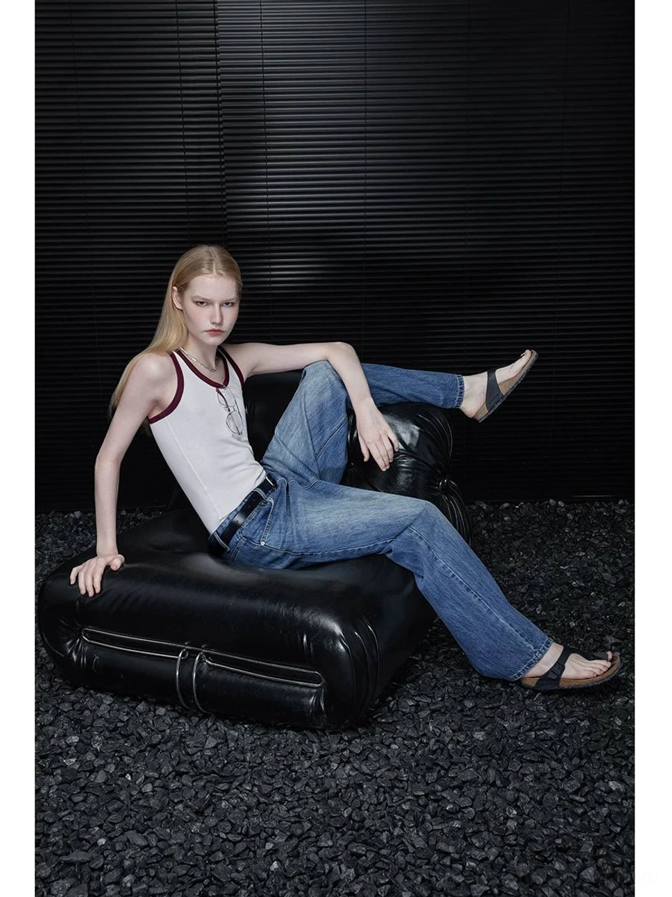 Seated outfit view of women’s vintage wash barrel leg jeans featuring relaxed wide curved legs and faded blue denim texture