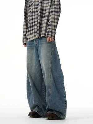 Side front view of faded blue ultra wide-leg balloon jeans with relaxed curved denim silhouette