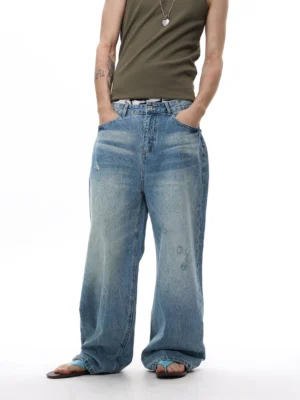Front view of faded blue vintage wash wide-leg balloon jeans styled with an olive tank top for Y2K streetwear