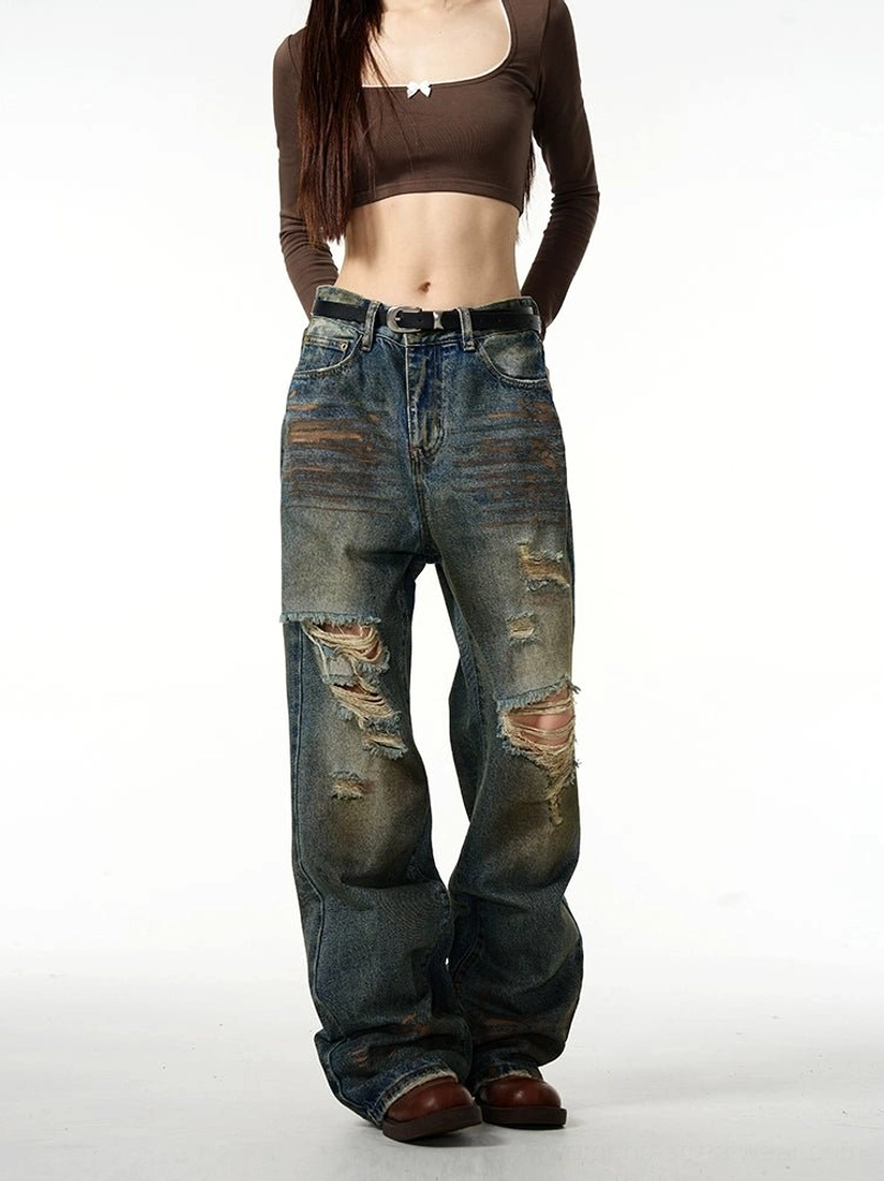 Front view of vintage washed blue baggy ripped denim jeans with oversized wide-leg fit and distressed knee details