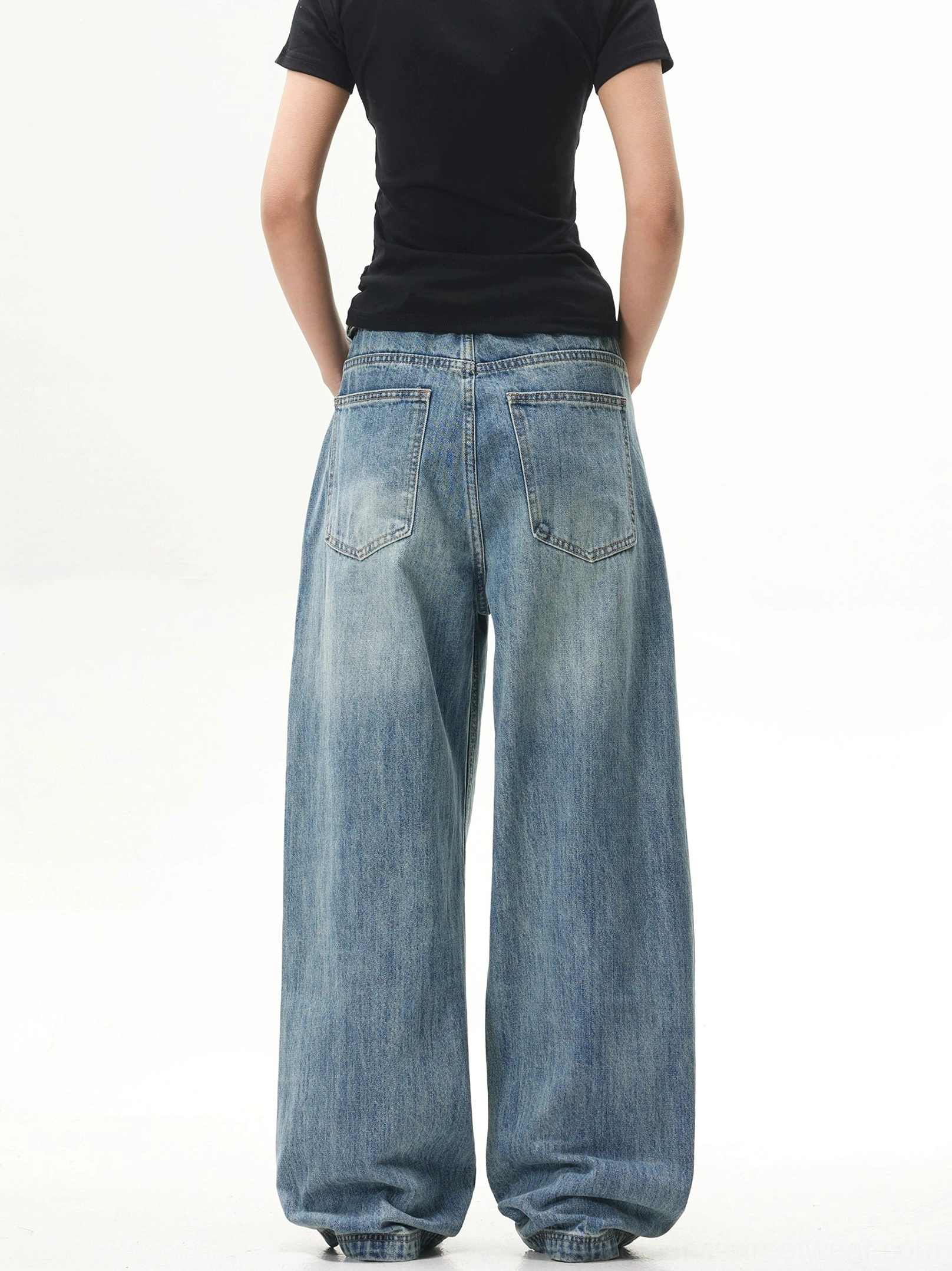 Back view of vintage washed blue ultra-wide jeans with stitched rear pockets and a relaxed oversized streetwear leg