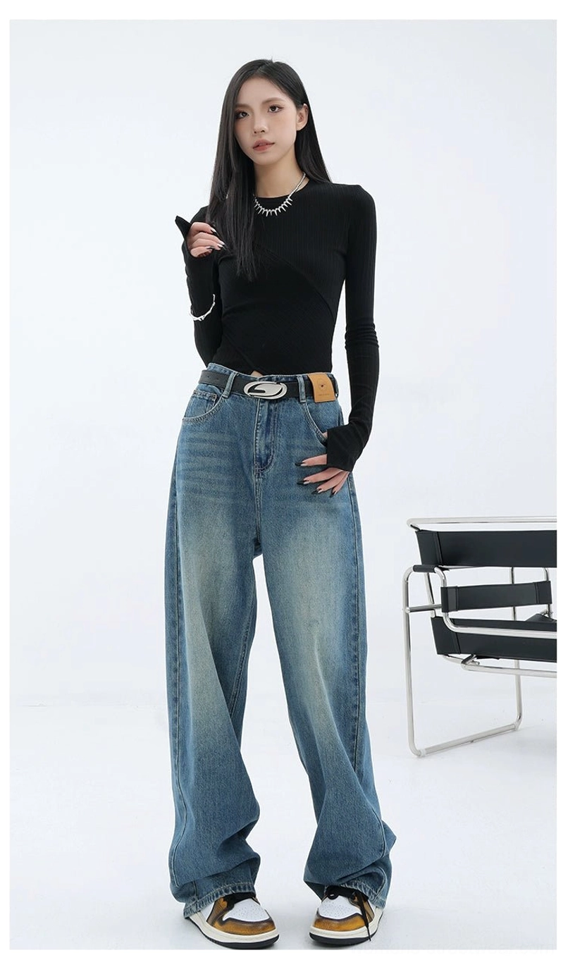 Vintage washed blue wide-leg denim jeans styled with a fitted black long-sleeve top, chain accessories, and an elevated urban streetwear outfit