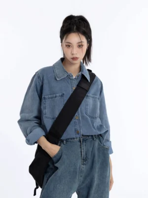 Women's vintage washed dark blue denim shirt jacket in a relaxed loose fit styled with matching wide-leg denim pants and a black crossbody bag