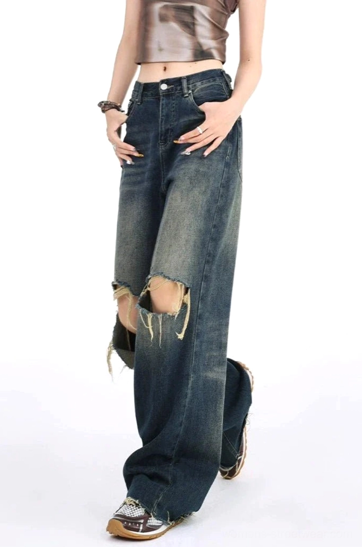 Right side full-body image of vintage washed distressed wide leg jeans with double frayed knee rips, high-waisted loose fit, cropped styling, and retro streetwear accessories