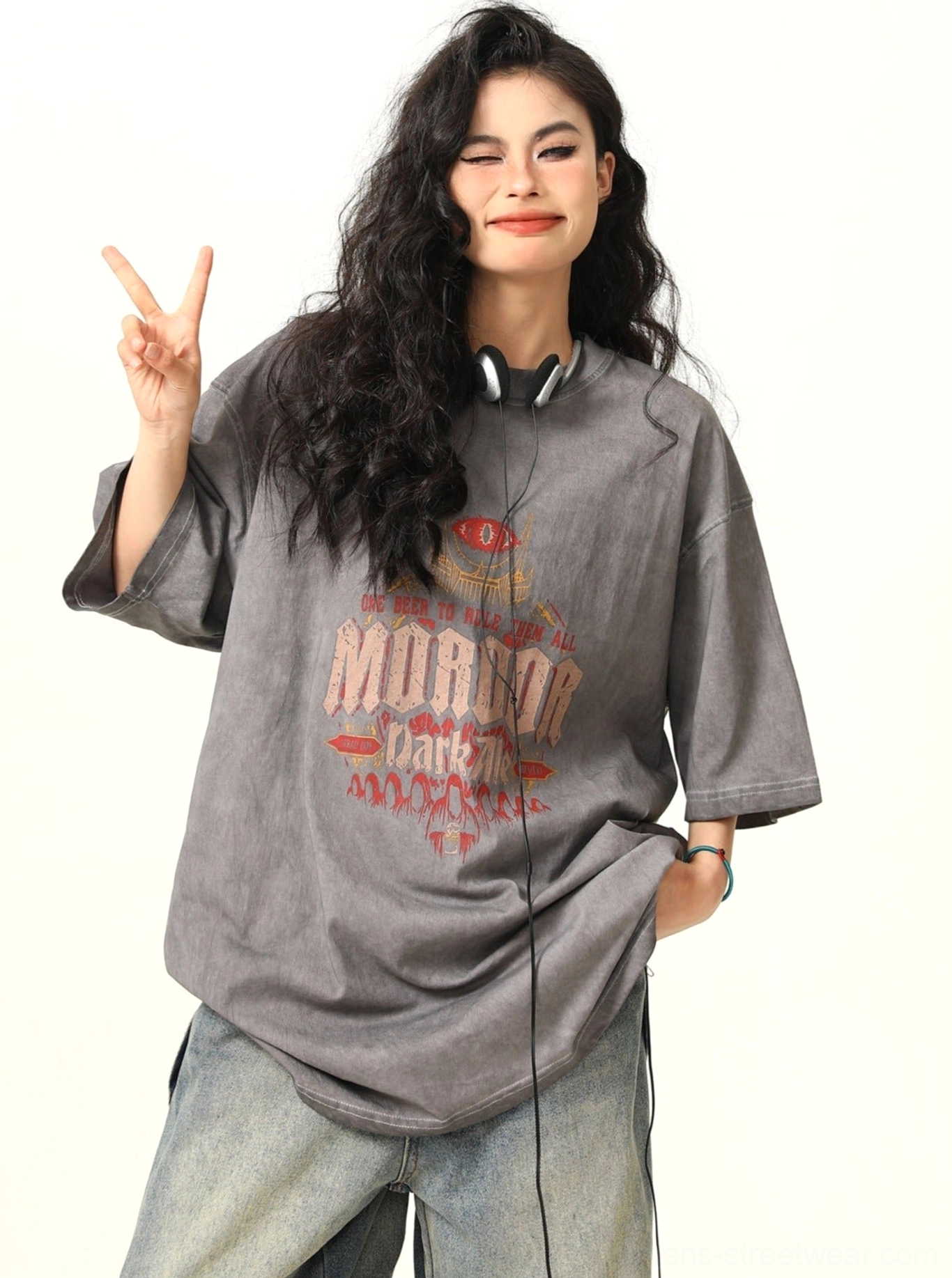 Three-quarter view of a woman wearing a vintage washed gray fantasy graphic oversized T-shirt with loose drop shoulder sleeves
