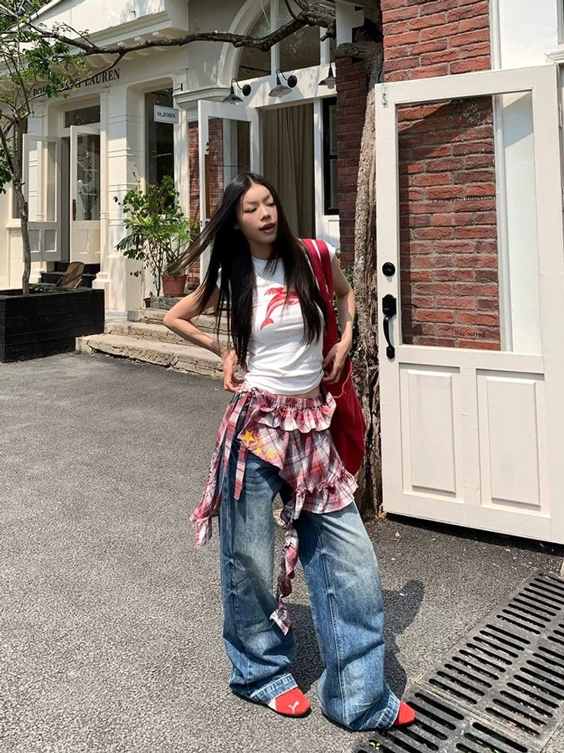 Three-quarter view of vintage washed low-rise wide-leg jeans with worn-in denim texture and plaid waist styling