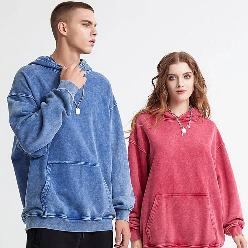 Blue and rose pink acid washed oversized hoodies worn by models with relaxed drop-shoulder streetwear fit
